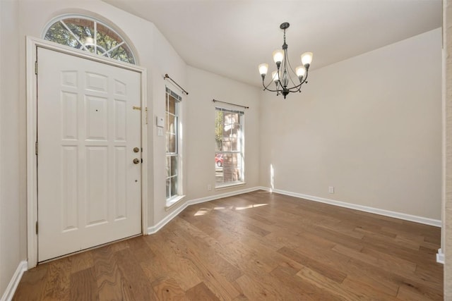 entrance foyer with an inviting chandelier and hardwood / wood-style floors