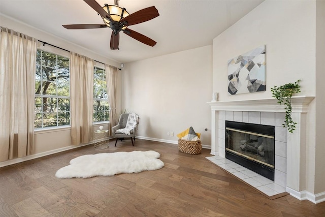 living area featuring hardwood / wood-style flooring, a fireplace, and ceiling fan