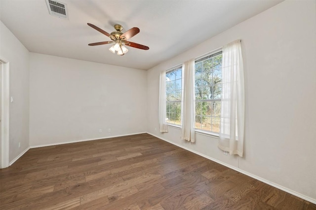 empty room with dark hardwood / wood-style floors and ceiling fan