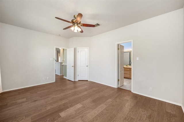 unfurnished bedroom with connected bathroom, hardwood / wood-style flooring, and ceiling fan