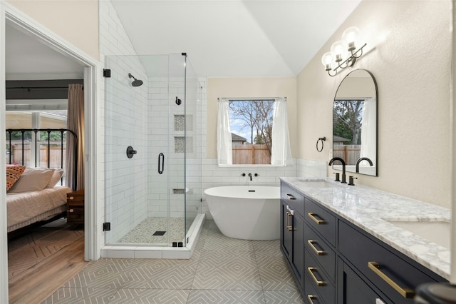 bathroom featuring vaulted ceiling, tile walls, vanity, separate shower and tub, and tile patterned floors