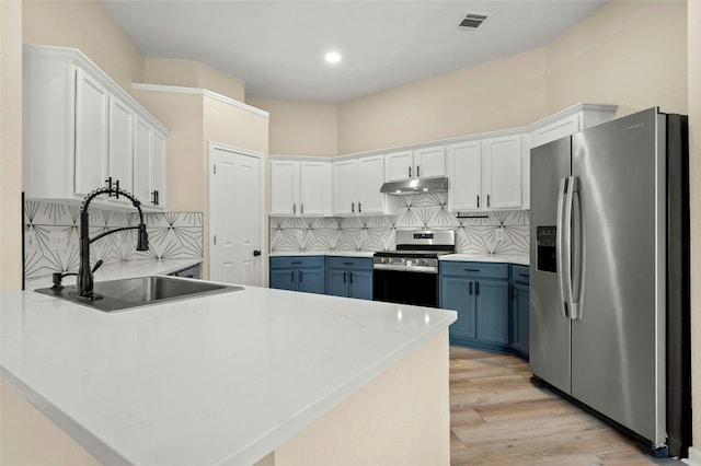 kitchen featuring blue cabinetry, appliances with stainless steel finishes, sink, and white cabinets