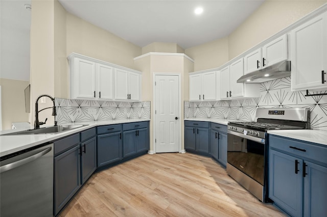 kitchen featuring white cabinetry, blue cabinetry, and appliances with stainless steel finishes