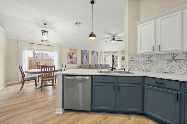 kitchen with sink, white cabinetry, stainless steel dishwasher, a wealth of natural light, and pendant lighting