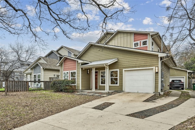 view of front of home featuring board and batten siding, concrete driveway, and fence