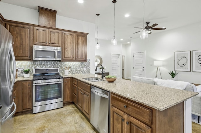 kitchen featuring pendant lighting, sink, stainless steel appliances, and kitchen peninsula