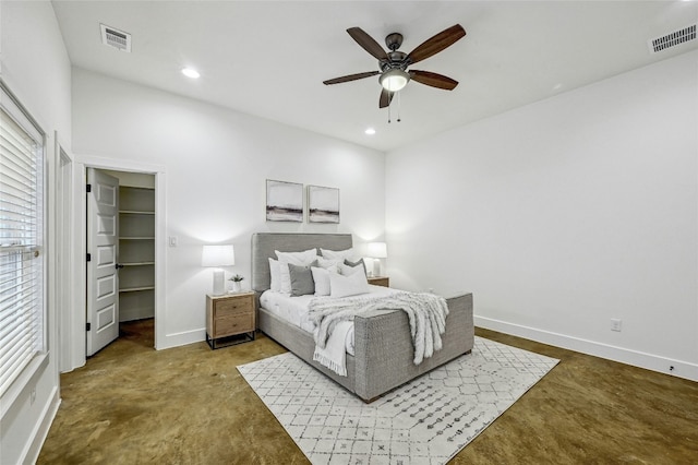 carpeted bedroom featuring ceiling fan and a walk in closet