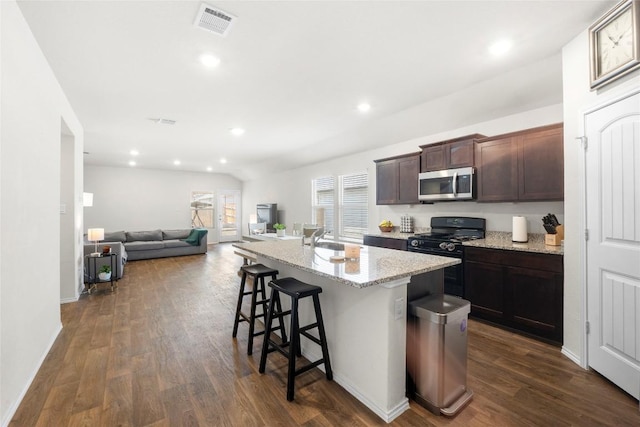 kitchen with stainless steel microwave, dark wood-style floors, visible vents, and black range with gas stovetop