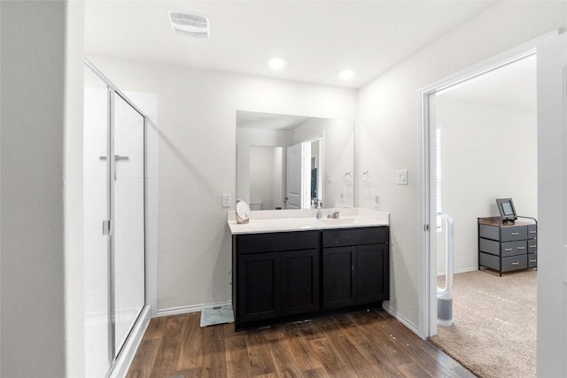 bathroom with visible vents, a shower stall, baseboards, wood finished floors, and vanity