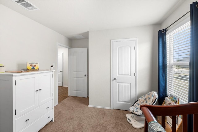 bedroom with light colored carpet, visible vents, and baseboards