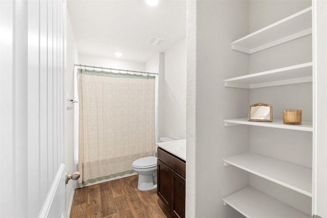 full bathroom featuring toilet, vanity, a shower with curtain, and wood finished floors