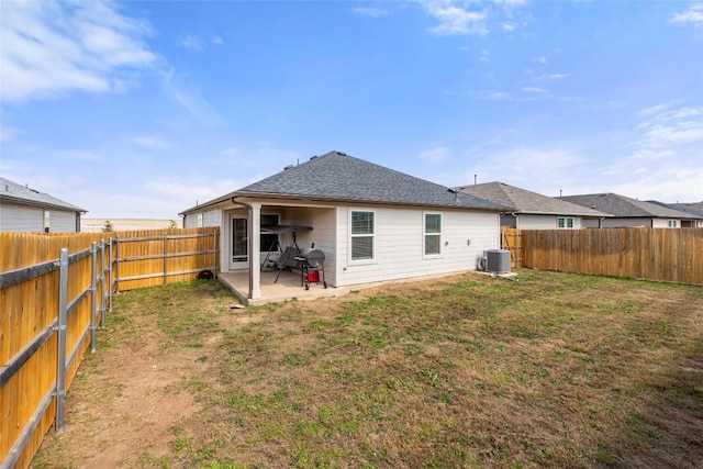 rear view of house featuring central AC unit, a patio area, a lawn, and a fenced backyard