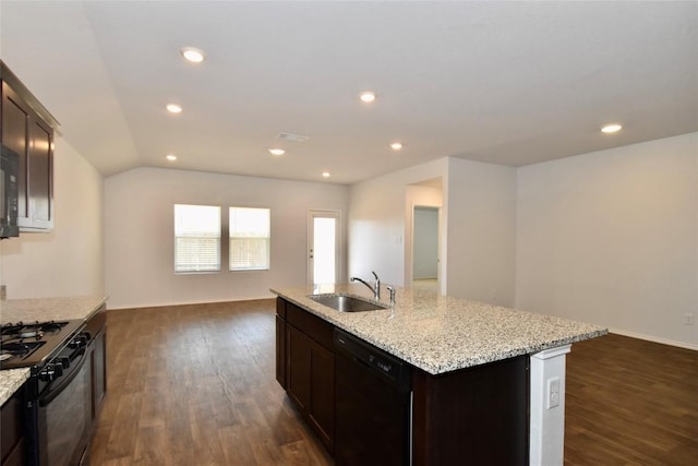 kitchen featuring dark wood-type flooring, sink, an island with sink, and black appliances