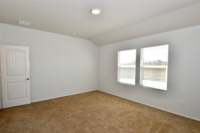 unfurnished room featuring vaulted ceiling and light carpet