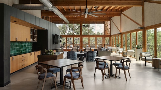 dining area featuring floor to ceiling windows, concrete flooring, a ceiling fan, and a towering ceiling