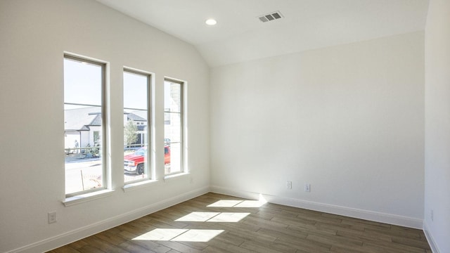 spare room featuring visible vents, baseboards, and wood finished floors