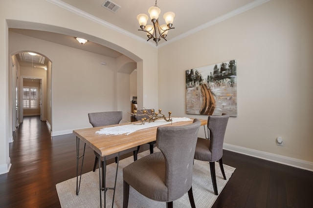 dining space with ornamental molding, dark wood-type flooring, and a notable chandelier