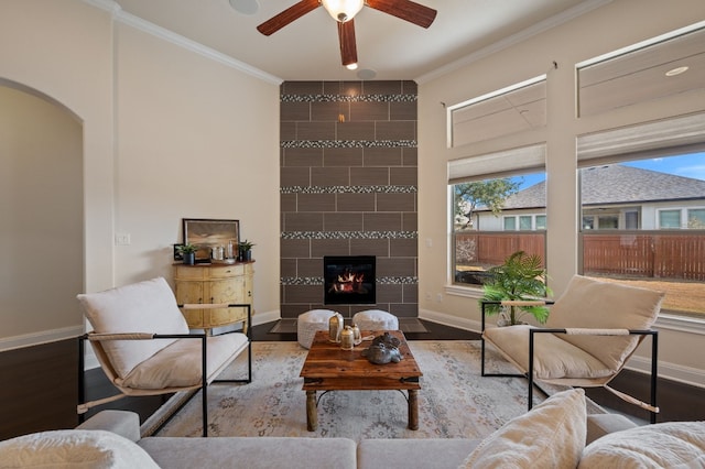 living room with crown molding, wood-type flooring, and a fireplace