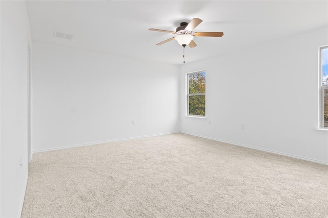 unfurnished room featuring baseboards, visible vents, a ceiling fan, and carpet