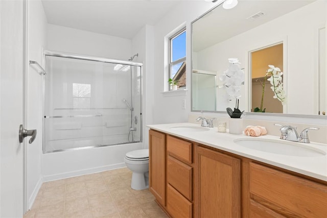 full bathroom with vanity, tile patterned flooring, bath / shower combo with glass door, and toilet