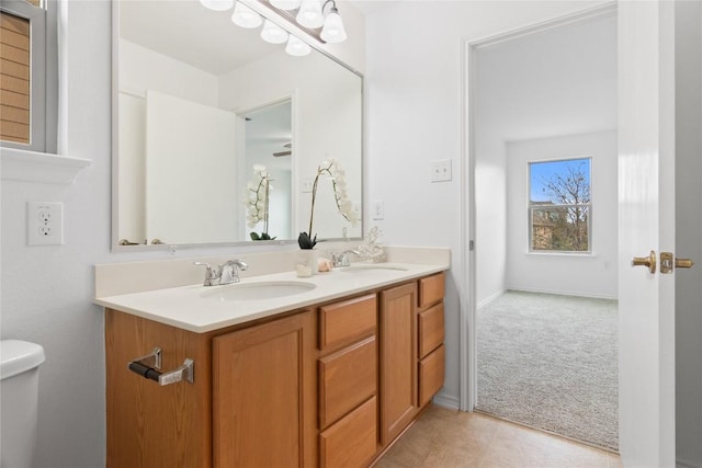 full bathroom with double vanity, toilet, tile patterned floors, and a sink