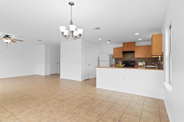 kitchen featuring ceiling fan with notable chandelier, white refrigerator, decorative backsplash, black range with electric cooktop, and decorative light fixtures