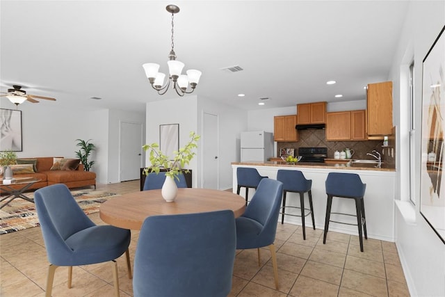 dining room featuring sink, ceiling fan with notable chandelier, and light tile patterned flooring