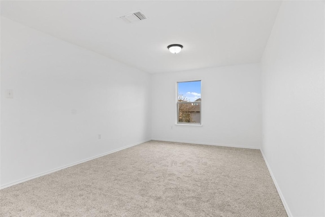 carpeted empty room with visible vents and baseboards