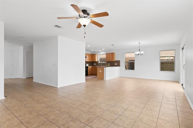 unfurnished living room with ceiling fan with notable chandelier and light tile patterned floors