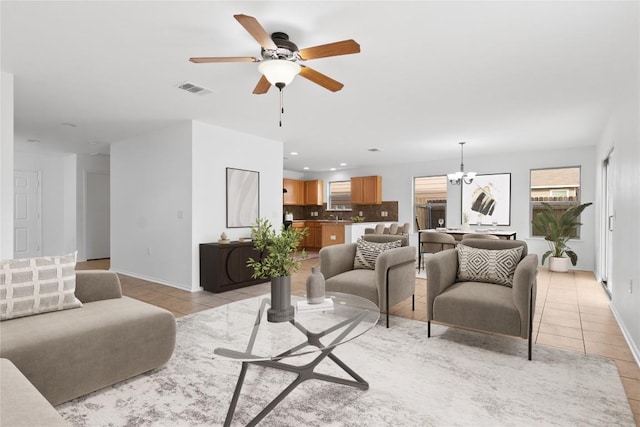 living room featuring visible vents, ceiling fan with notable chandelier, recessed lighting, light tile patterned floors, and baseboards