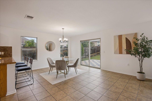 11009 Roderick Lawson Ln, Austin, TX 78754 - dining area featuring light tile patterned floors, a chandelier, and baseboards