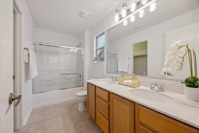 11009 Roderick Lawson Ln, Austin, TX 78754 - full bath featuring double vanity, combined bath / shower with glass door, toilet, and tile patterned floors