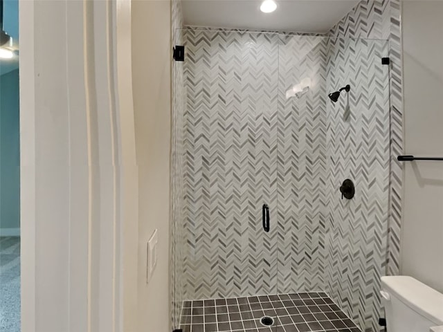 bathroom with tiled shower and toilet