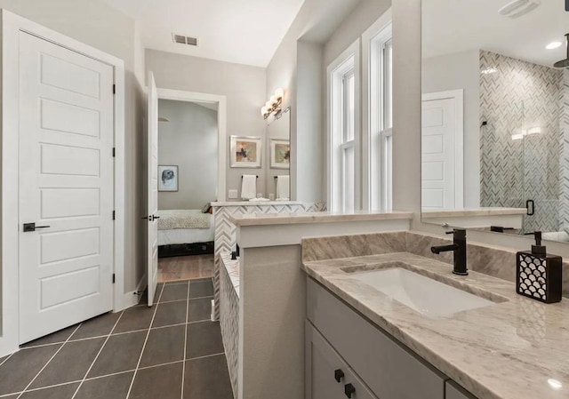 bathroom featuring tile patterned flooring, vanity, and tiled shower