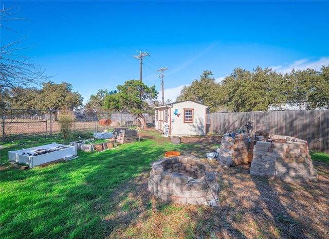 view of yard featuring an outbuilding and a fire pit