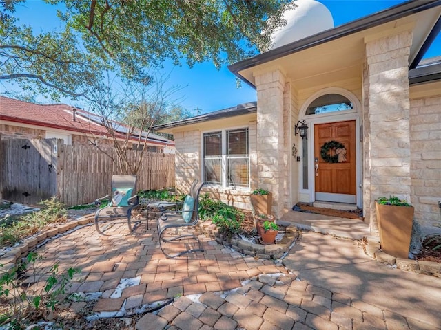 view of exterior entry with a patio