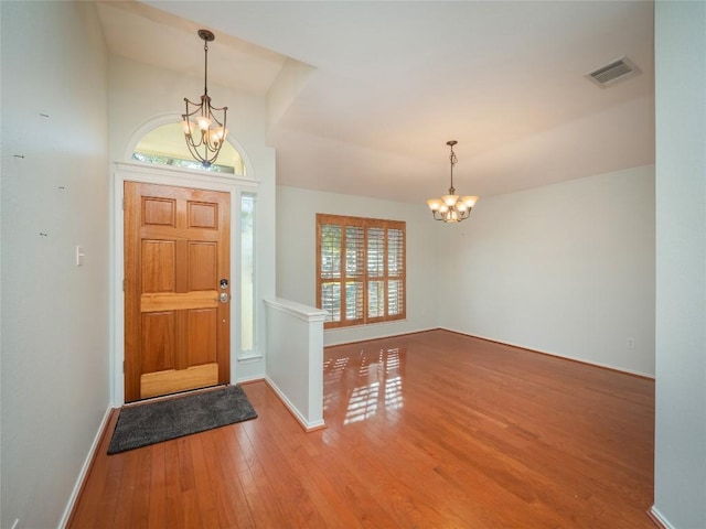 entrance foyer with hardwood / wood-style flooring and a chandelier