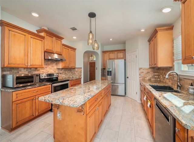 kitchen with a kitchen island, sink, hanging light fixtures, light stone counters, and stainless steel appliances