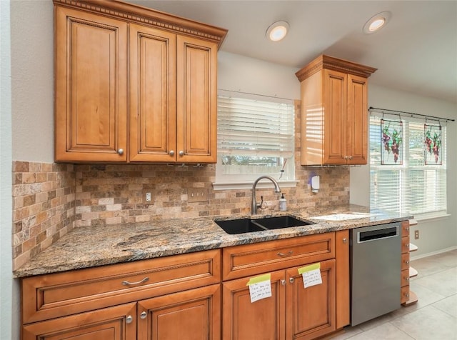 kitchen with dishwasher, sink, a wealth of natural light, and light stone counters