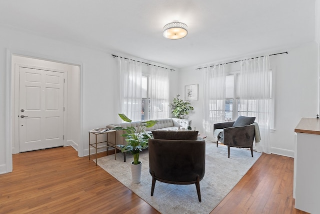 living area with baseboards and hardwood / wood-style floors