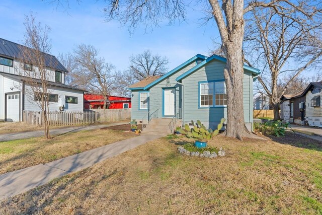 bungalow-style house featuring a front lawn