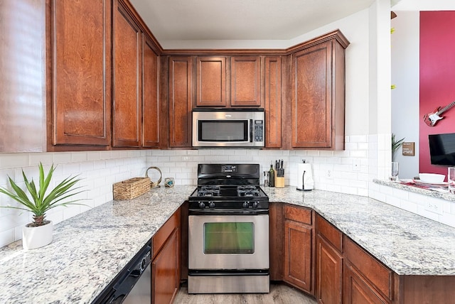 kitchen with decorative backsplash, light stone countertops, light hardwood / wood-style floors, and appliances with stainless steel finishes