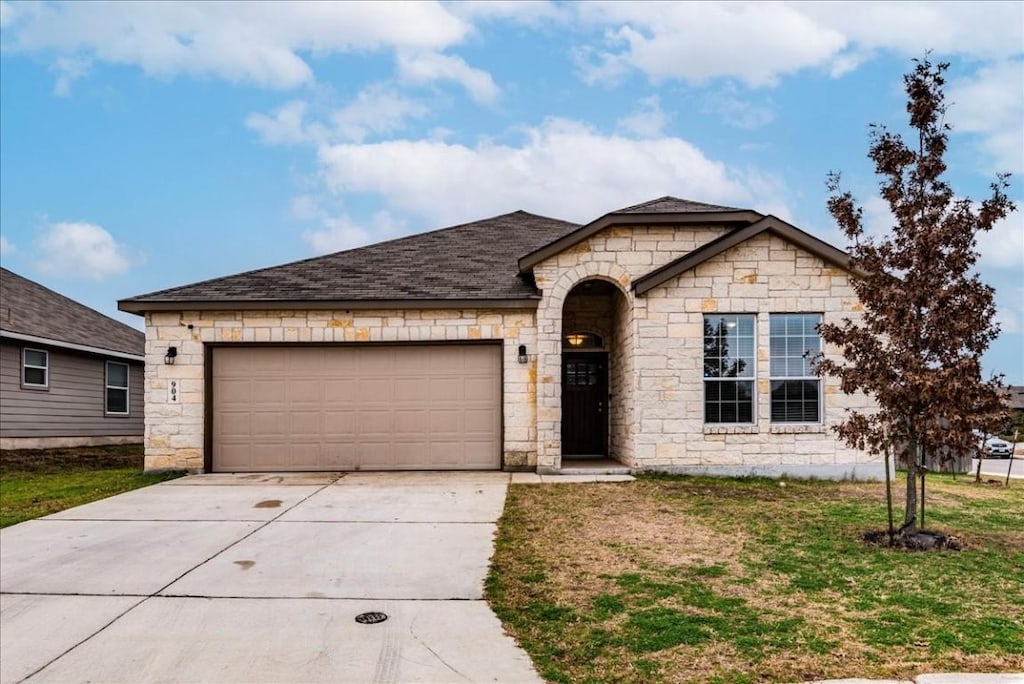 single story home with a garage and a front lawn