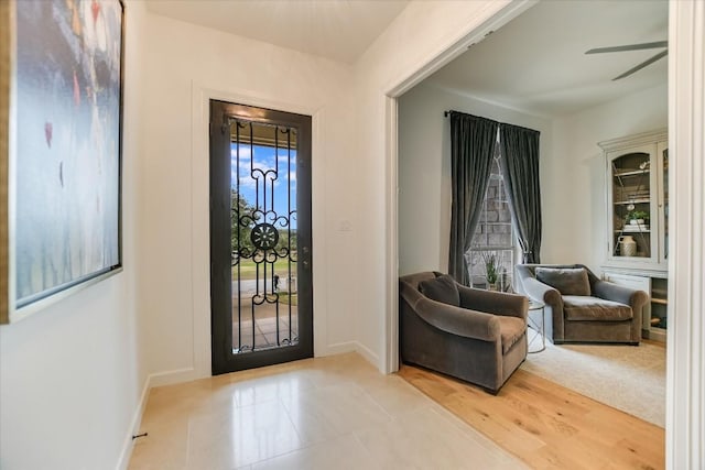 foyer with a wealth of natural light, light hardwood / wood-style floors, and ceiling fan