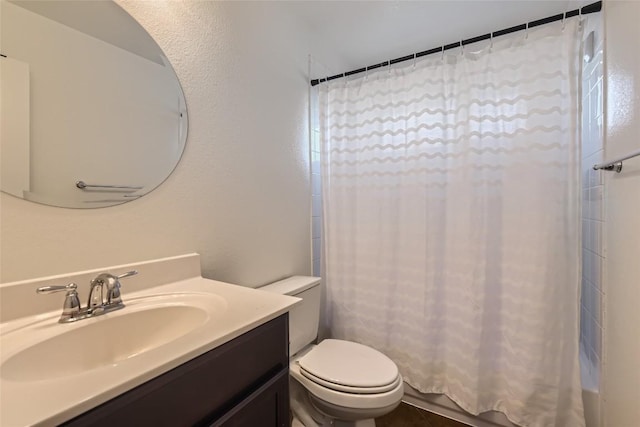 bathroom featuring vanity, walk in shower, and toilet