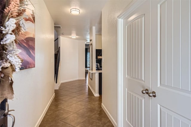 hallway featuring dark tile patterned floors