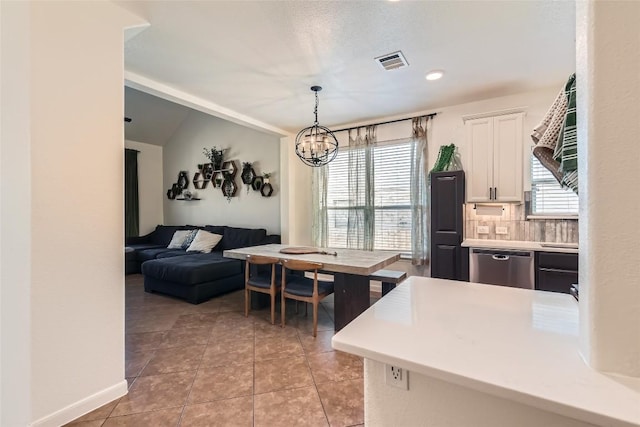 kitchen featuring pendant lighting, a wealth of natural light, dishwasher, and white cabinets