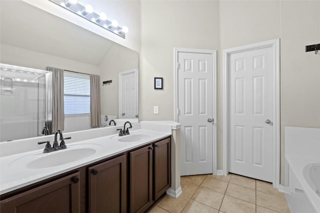 bathroom featuring a tub to relax in, tile patterned floors, vanity, and lofted ceiling