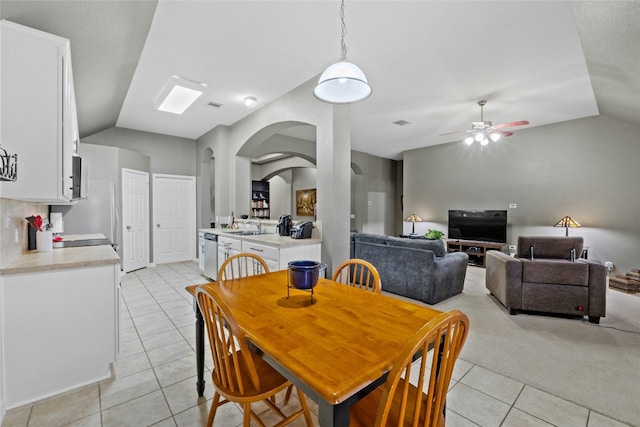 dining area featuring vaulted ceiling, sink, light tile patterned flooring, and ceiling fan