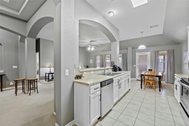 kitchen with appliances with stainless steel finishes, decorative light fixtures, white cabinetry, sink, and light tile patterned floors